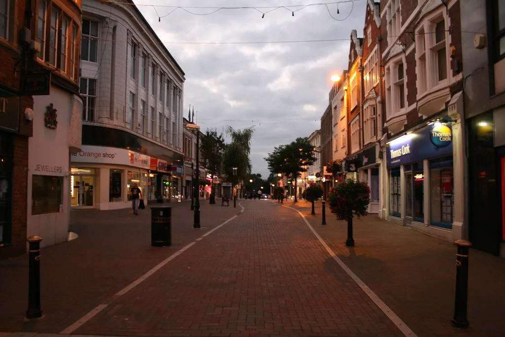 A pedestrianised shopping street in Stafford town centre at dusk. The group rule applies in the pedestrianised areas of Stafford and Stone.